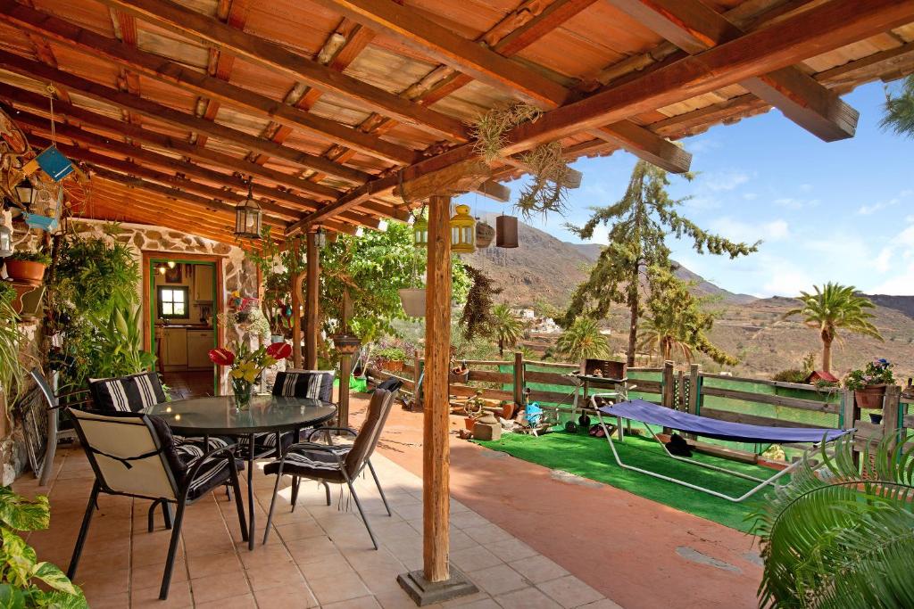 a patio with a table and chairs and a view at Casa Los Pinos in Agüimes