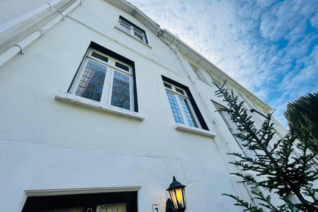 um edifício branco com duas janelas e uma luz de rua em NomiHomes-Otis House-Free Parking x 2-Central -10ppl em Exeter