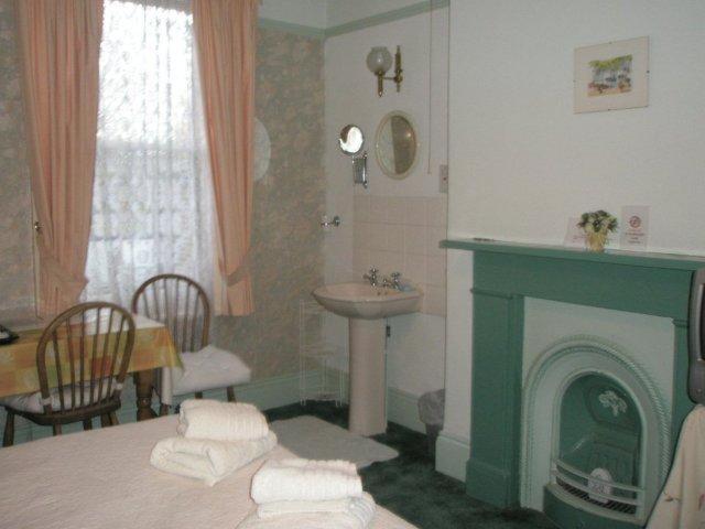 een badkamer met een open haard, een wastafel en een wastafel bij Kew Gardens National Archives Forest Road in Londen