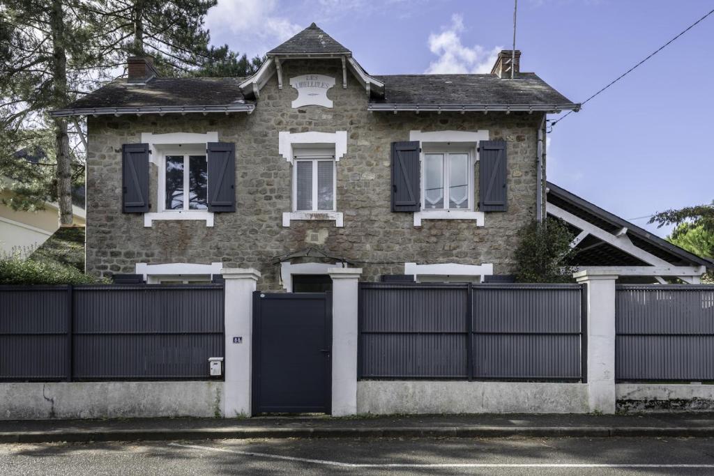 ein Backsteinhaus mit einem Tor und einem Zaun in der Unterkunft Villa Les Libellules pour 8 à 9 personnes in La Baule