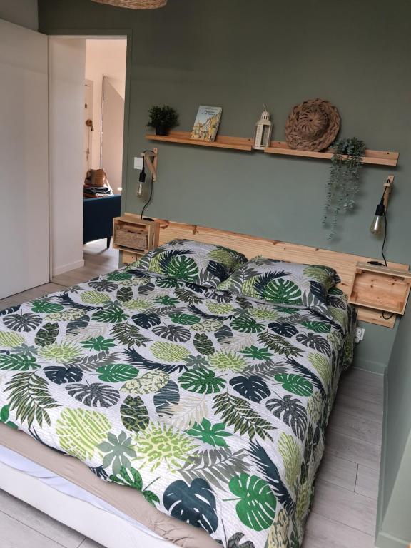 a bedroom with a bed with a green and white comforter at Détente provinoise in Provins