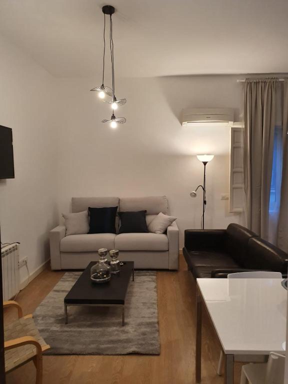 una sala de estar con un sofá y una mesa en Le Petit Palü-Fuencarral, en Madrid