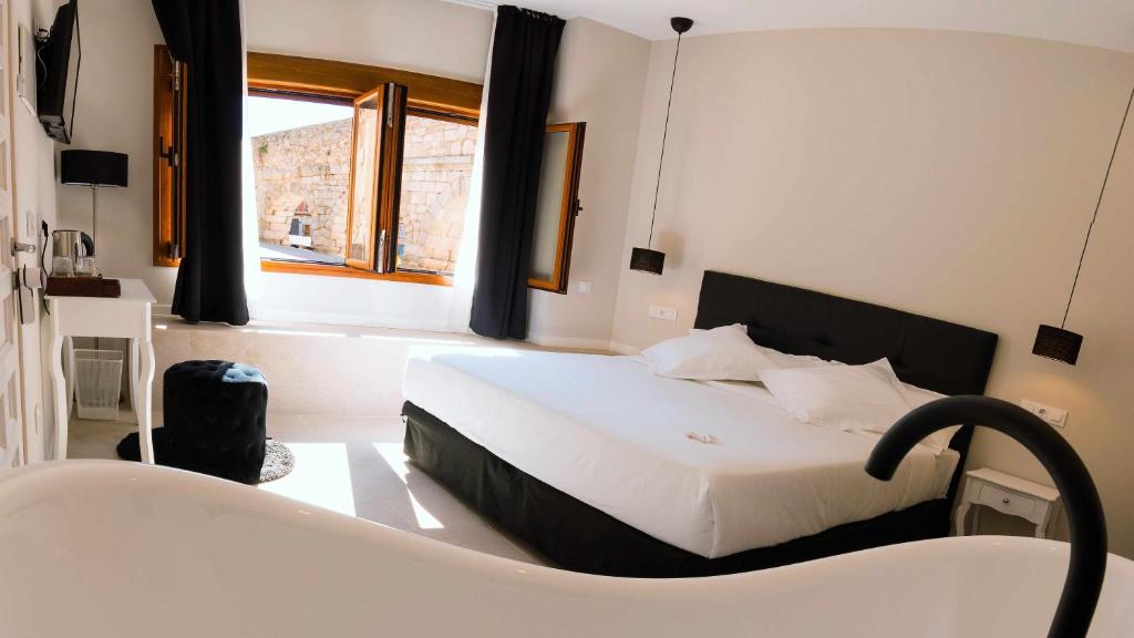 a bedroom with a bed and a bath tub and a bath tub at El silencio boutique room in Segovia