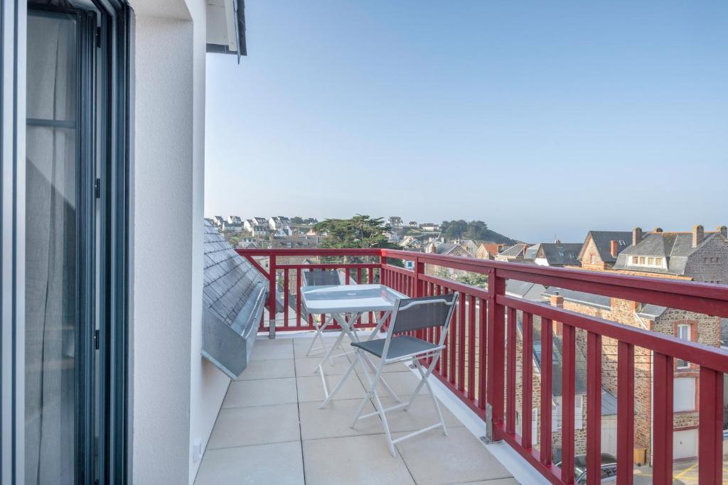 a balcony with a chair and a view of the city at Charmant appartement sur le remblai de Pleneuf Val Andre in Pléneuf-Val-André