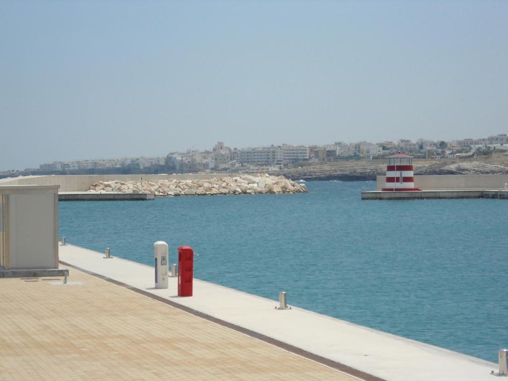 a dock with a red fire hydrant next to the water at Ville Alba & Azzurra in Polignano a Mare