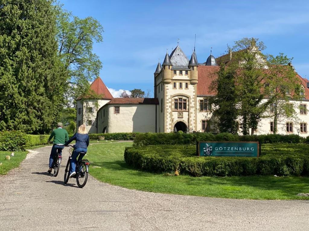 Un uomo e un bambino che vanno in bicicletta davanti a un castello. di Schlosshotel Götzenburg a Jagsthausen