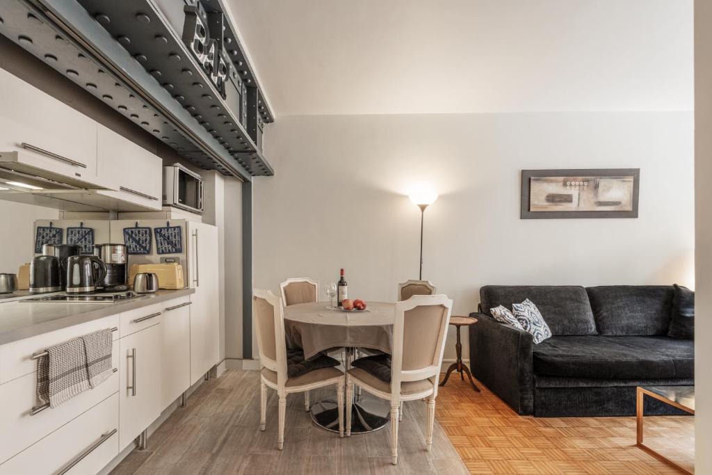 eine Küche und ein Esszimmer mit einem Tisch und einem Sofa in der Unterkunft Apart of Paris - Chatelet - Rue de Rivoli in Paris