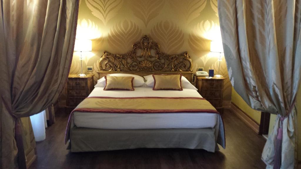 a bedroom with a large bed with two pillows at Hotel Amadeus in Venice