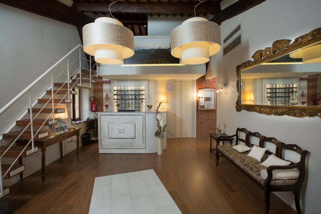 ein Wohnzimmer mit einer Treppe und einem Spiegel in der Unterkunft Hotel Alma Domus in Siena