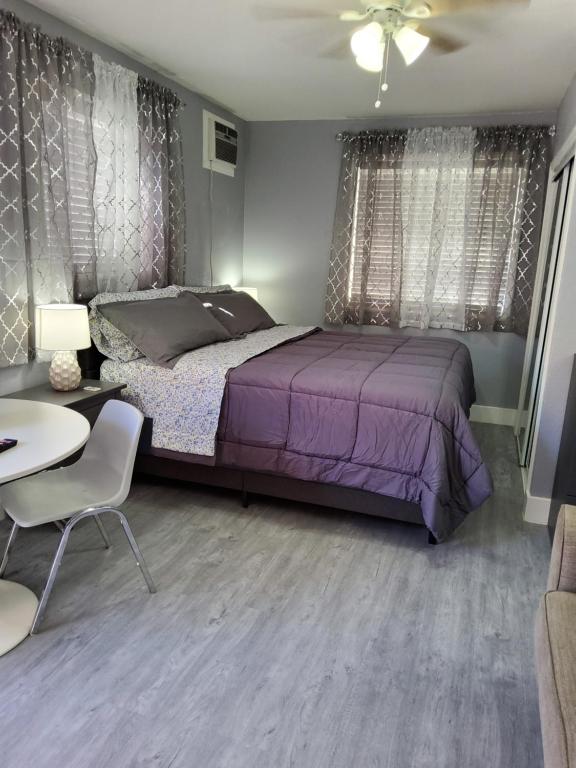 a bedroom with a purple bed and a table at habitación privada cerca de todo in Tampa