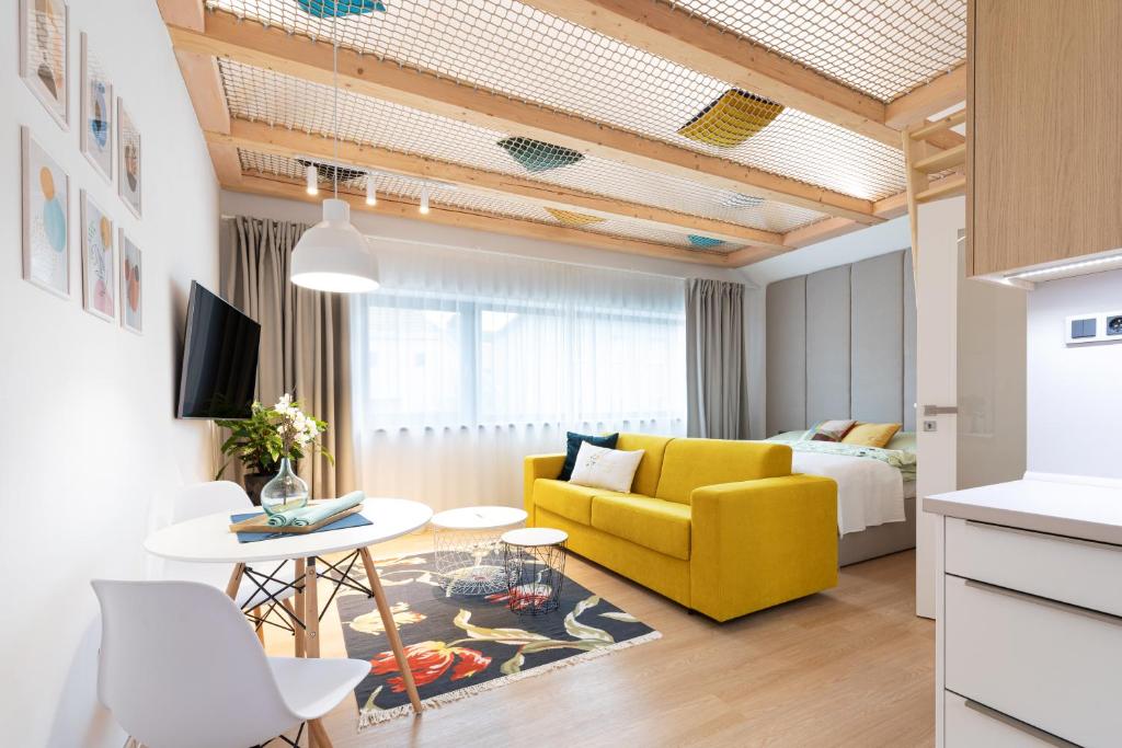 - un salon avec un canapé jaune et une table dans l'établissement RASL House, à Luka nad Jihlavou