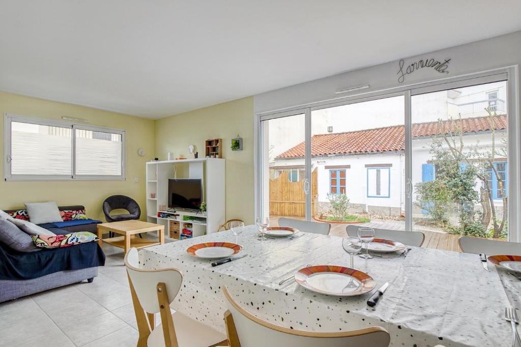 ein Wohnzimmer mit einem Tisch, Stühlen und einem Sofa in der Unterkunft Vacances à 10 à Saint-Jean-de-Monts in Saint-Jean-de-Monts