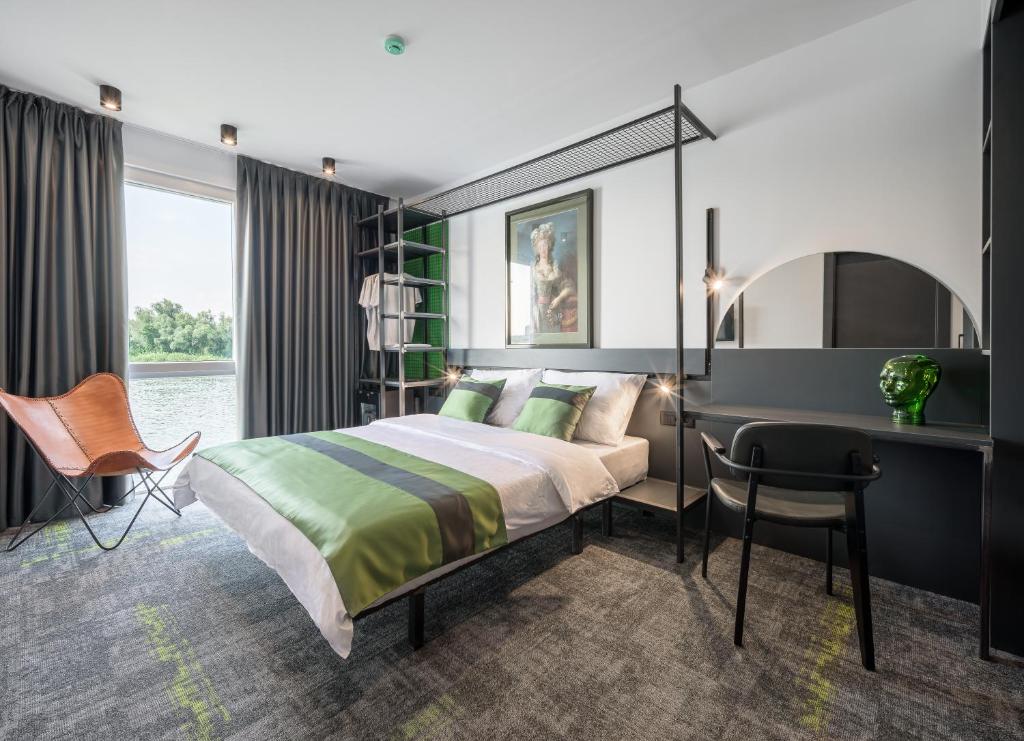 Schlafzimmer mit einem Bett, einem Schreibtisch und einem Stuhl in der Unterkunft Joy 5 Hotel & SPA in Belgrad