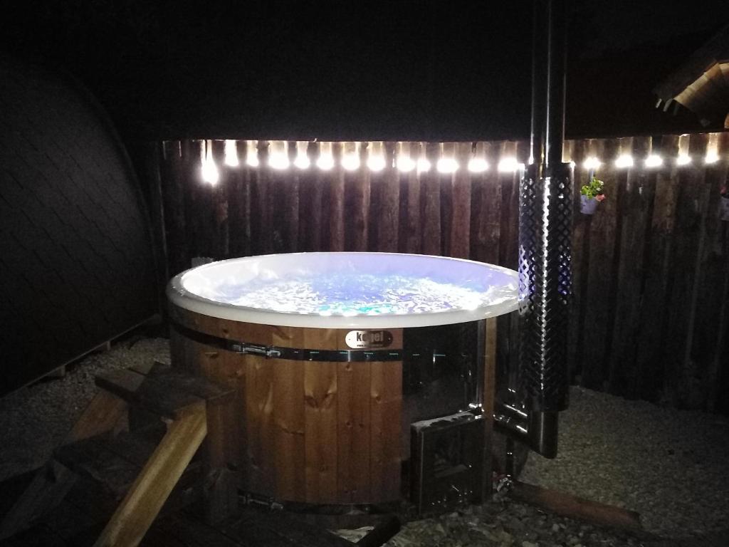 a bath tub with lights on a wooden fence at Wellness Kokořín in Kokořín