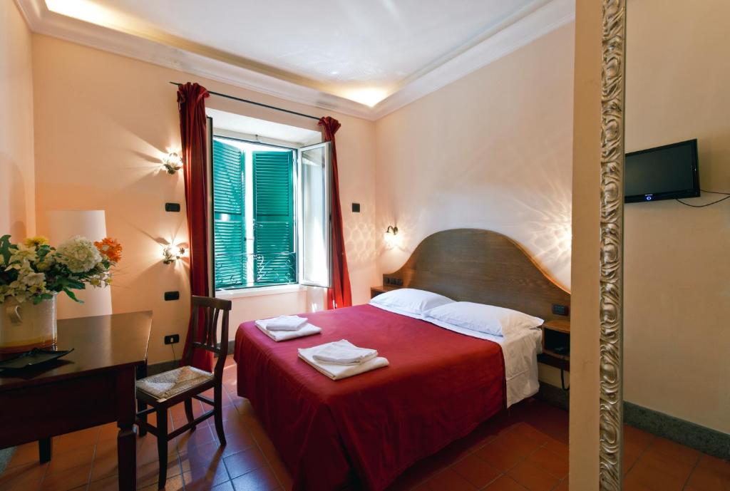 ローマにあるホテル アル サンピエトリーノの赤いベッドと窓が備わるホテルルームです。