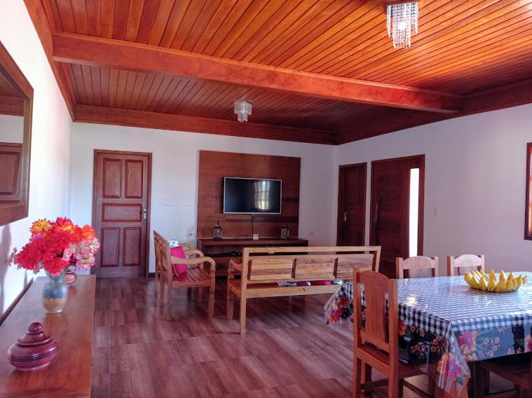 sala de estar con mesa de comedor y TV en Residencia Sao Miguel en Tiradentes