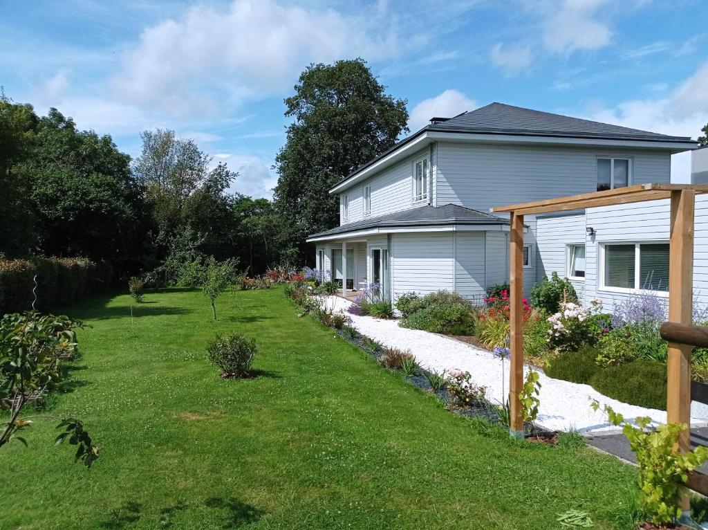 una casa con un cortile con erba verde di Le Clos Louisiane a Saint-Loup-Hors