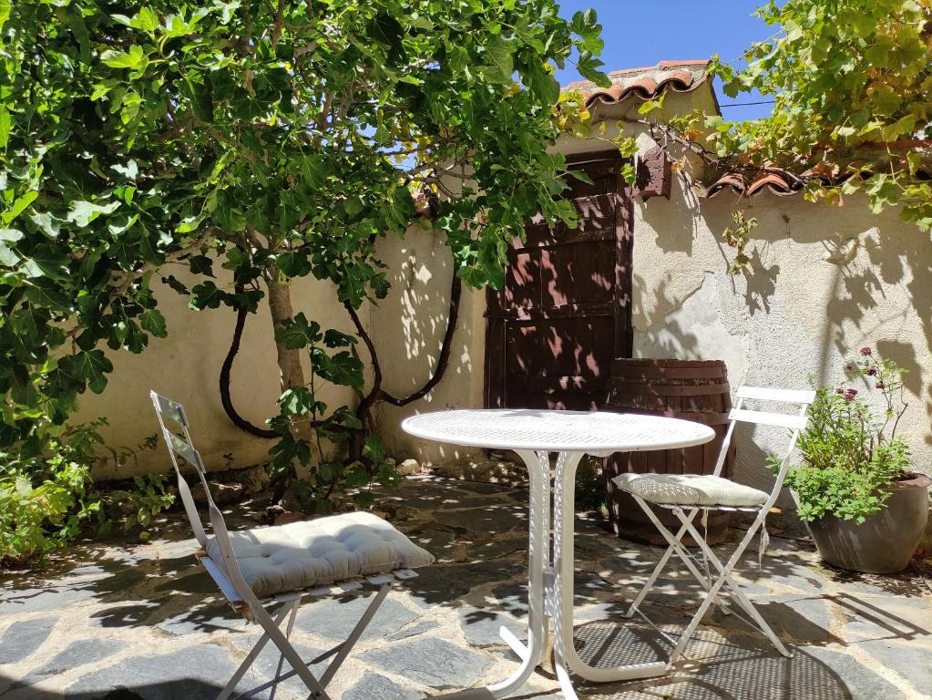 uma mesa e duas cadeiras e uma mesa e uma árvore em La Antigua casa del cartero em Roda de Eresma