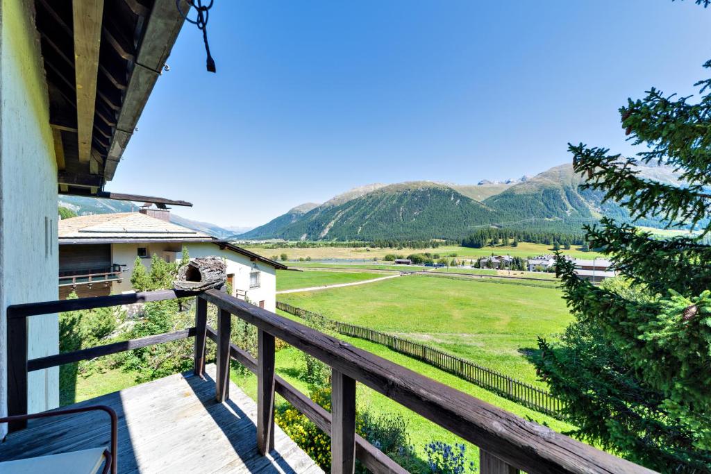 a balcony with a view of a field and mountains at Chesa Minouche - Celerina in Celerina