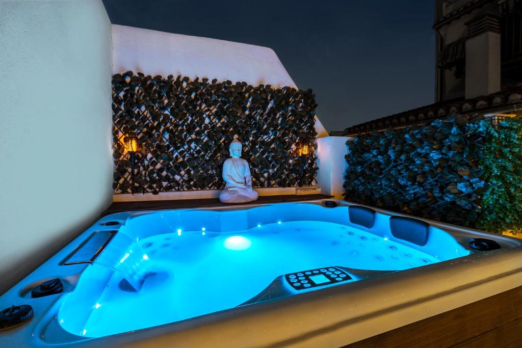 uma banheira de hidromassagem num quarto com uma parede cheia de pedras em Granaxperience Apartamentos La Maleta em Granada