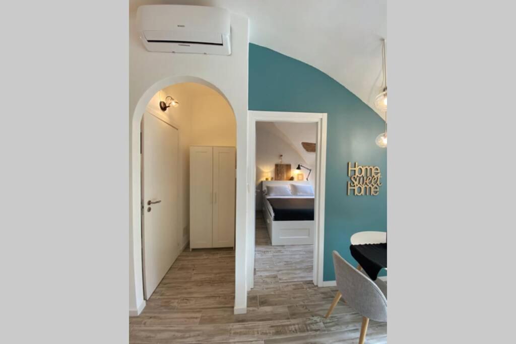 Habitación con pasillo con espejo y dormitorio. en Casa Meraki - Apartment en Bérgamo