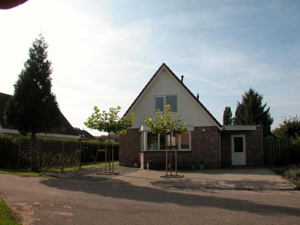 une maison avec deux arbres devant elle dans l'établissement Park Nest, à Zeewolde
