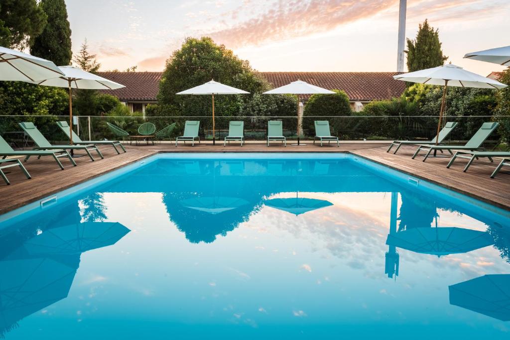 - une piscine avec des chaises longues et des parasols dans l'établissement Résidence de Diane - Toulouse, à Toulouse