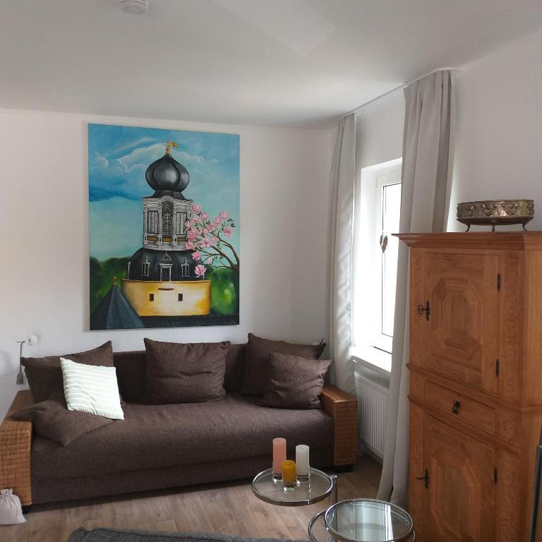 a living room with a couch and a painting on the wall at Friesenauster - große Ferienwohnung für bis zu 6 Personen in Jever