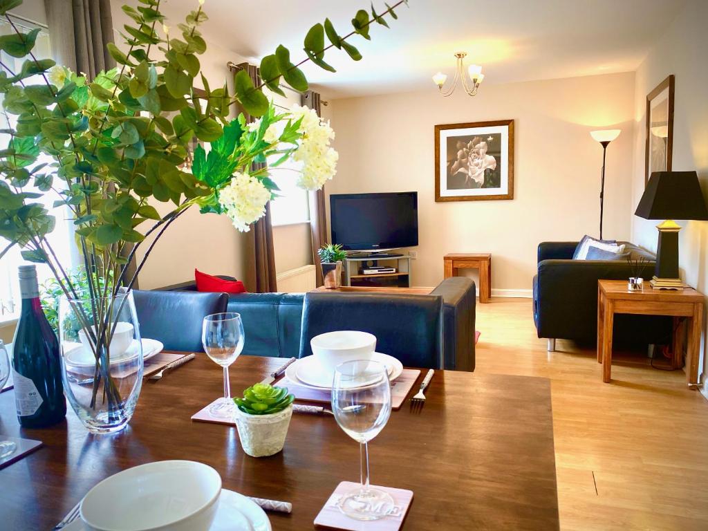 una sala de estar con una mesa con copas de vino. en Aylesbury Contractor & Staycation Home, en Aylesbury