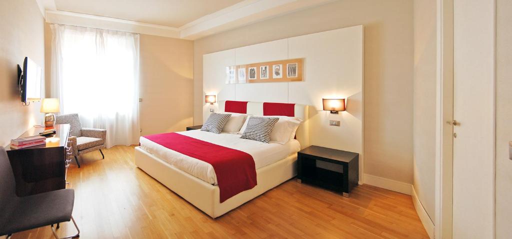 a bedroom with a bed with a red blanket at Adamas Luxury Suite in Rome