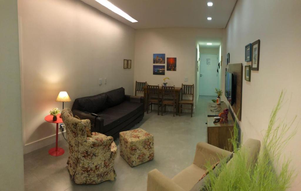 sala de estar con sofá, sillas y mesa en Apartamento Leme - RJ, en Río de Janeiro