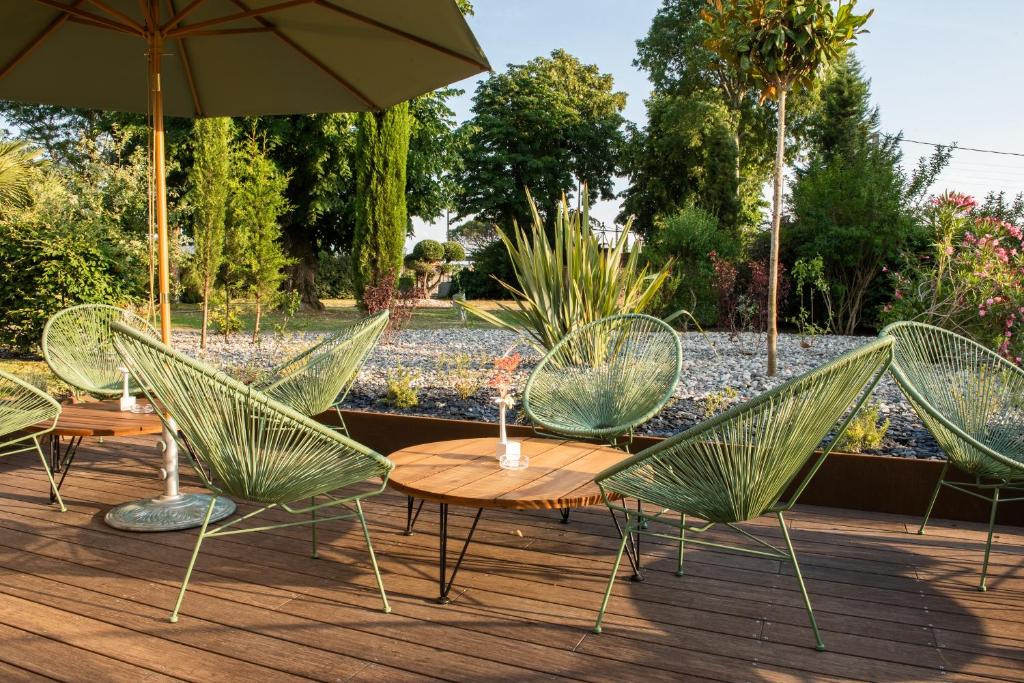 a group of chairs and tables with an umbrella at Résidence de Diane - Toulouse in Toulouse
