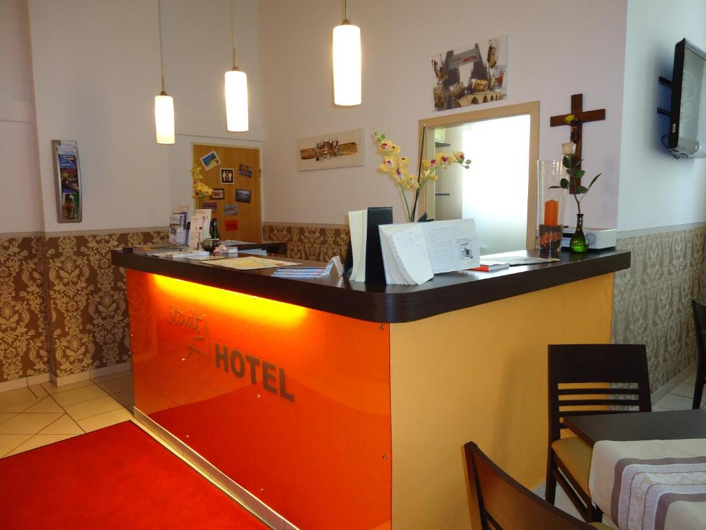 a lobby with an orange and yellow counter in a restaurant at Stadthotel Regensburg in Regensburg