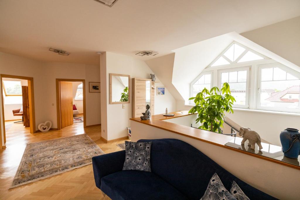 un soggiorno con divano blu e finestra di Apartment Ella a Klagenfurt