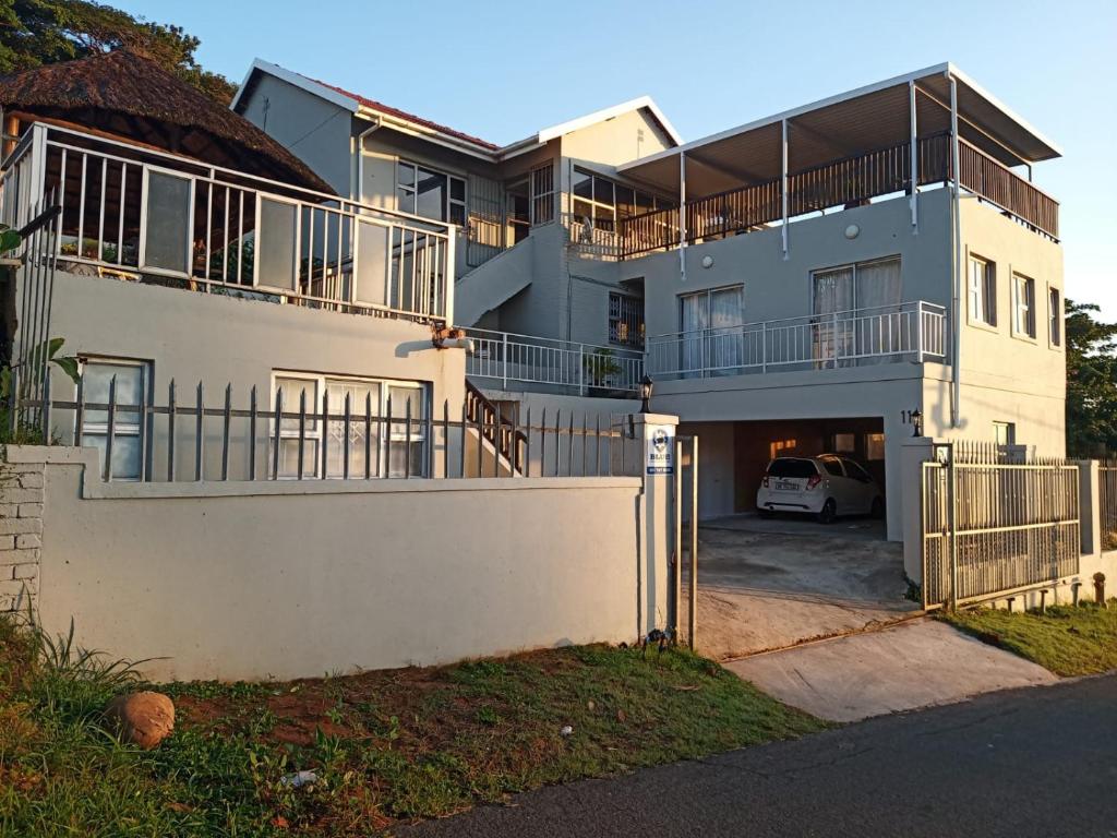 a large white house with a parking lot at Busis guesthouse in Durban