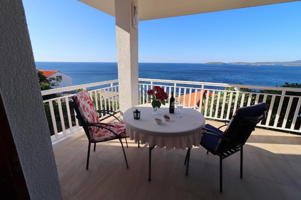 stół i krzesła na balkonie z widokiem na ocean w obiekcie Seaside Apartments Hrkać w Orebiciu