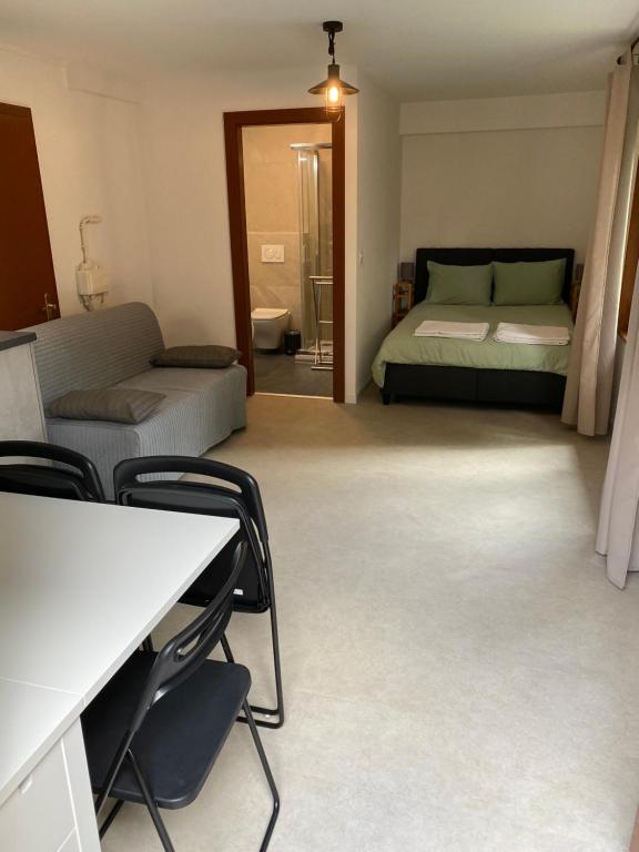 Zimmer mit einem Bett, einem Tisch und Stühlen in der Unterkunft Joli Studio près des Bains de Lavey in Savatan