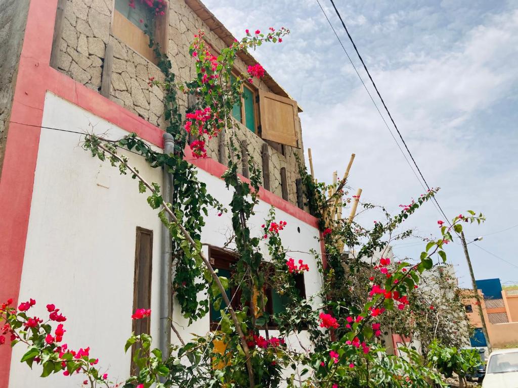 un bâtiment avec des fleurs sur son côté dans l'établissement Pedra de Rala, à Porto Novo