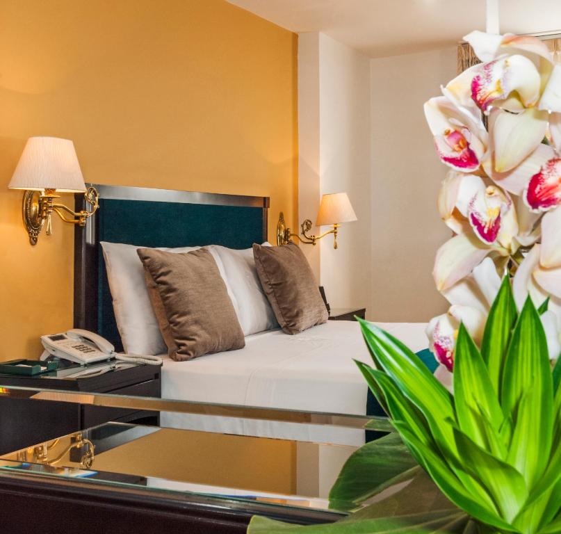Un pat sau paturi într-o cameră la Hotel Le Manoir Bogotá