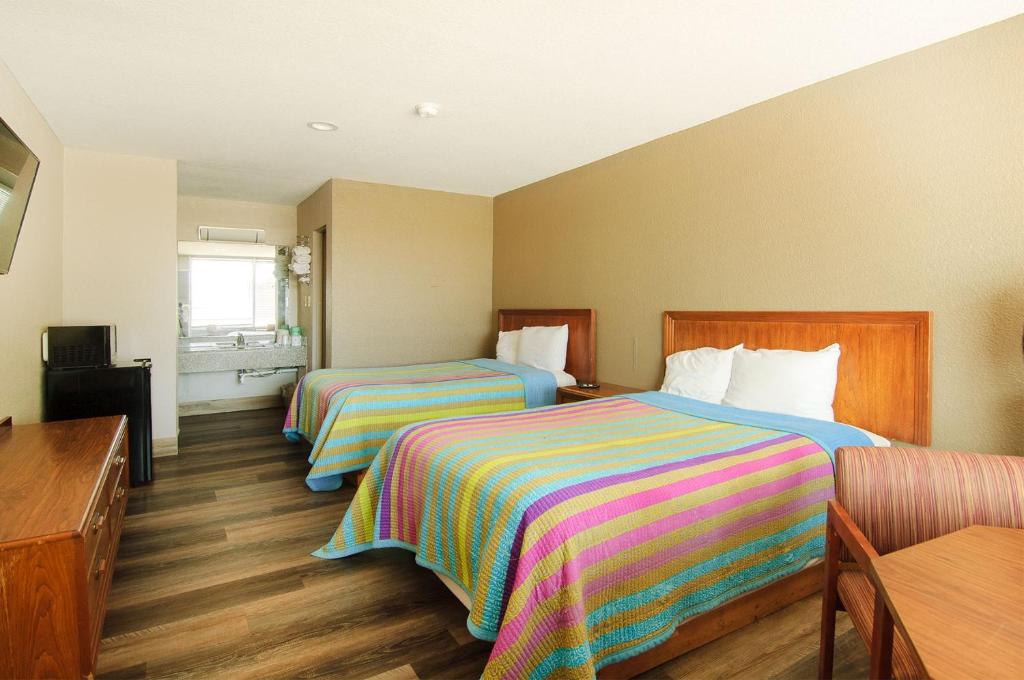 um quarto de hotel com duas camas e uma mesa em Town and Country INN em Rogers