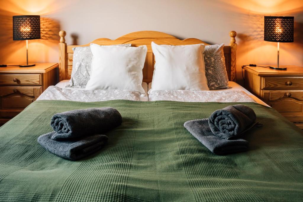 a bedroom with a bed with towels on it at Apartamenty Madzia in Wisła