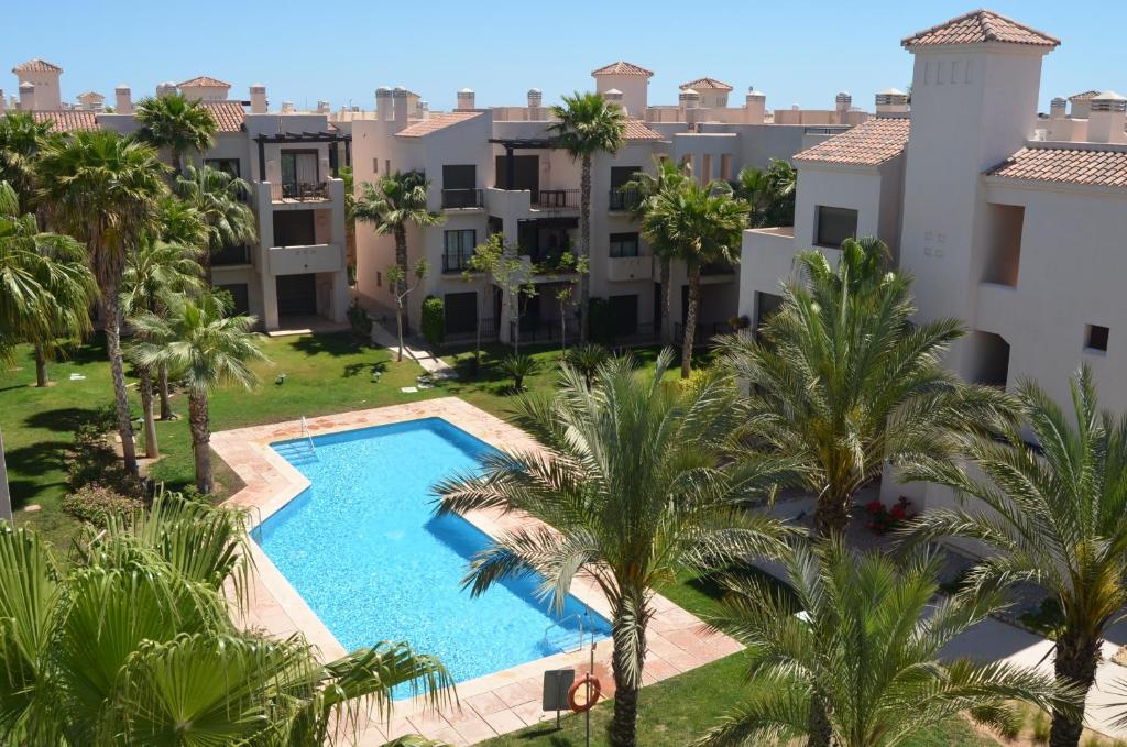 an aerial view of an apartment complex with a swimming pool and palm trees at Roda Golf Resort 5508 - Resort Choice in Roda