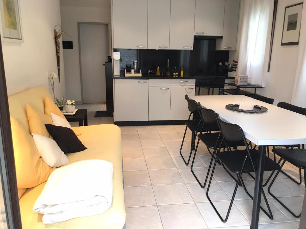 een woonkamer met een bank en een tafel met stoelen bij Appartamento da 2 locali a Bosco Gurin in Bosco Gurin
