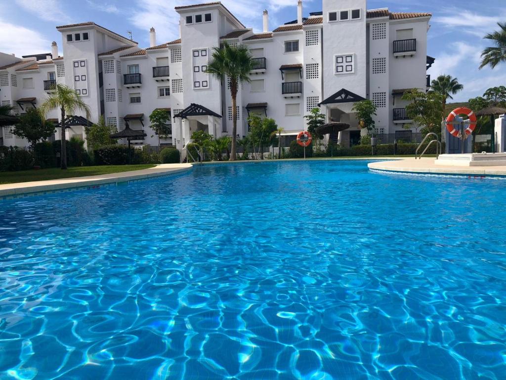 una gran piscina frente a un edificio en Residencial Duquesa, en San Luis de Sabinillas