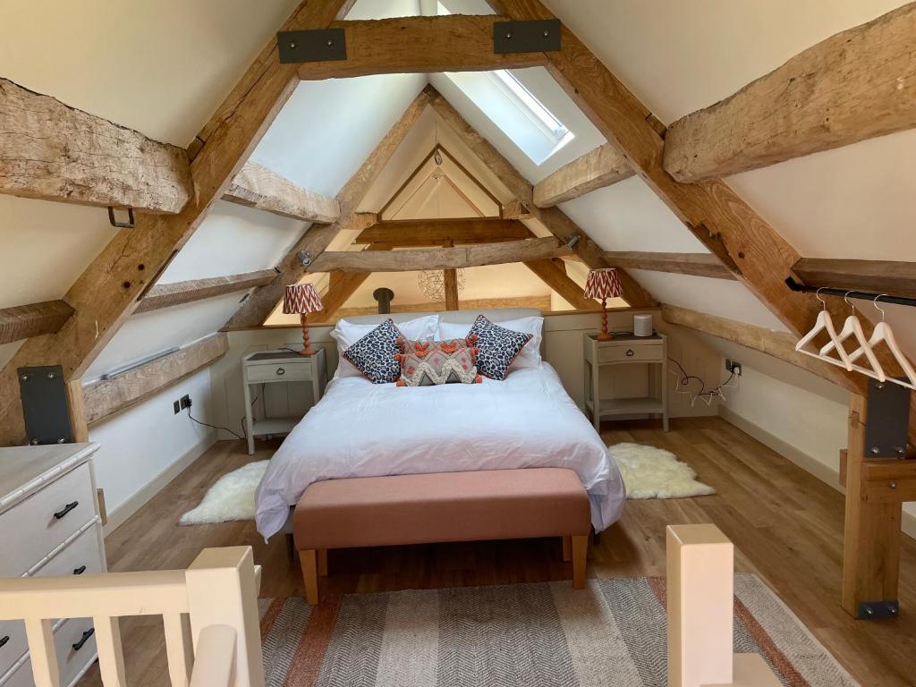 a bedroom with a bed in the attic at Wyke Cowsheds in Gillingham