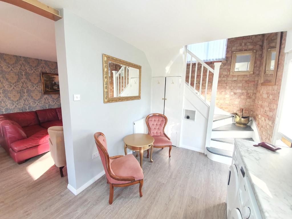 a living room with a table and chairs and a couch at St Georges house, Premium 3 bed Home Slough, Legoland, Windsor in Slough