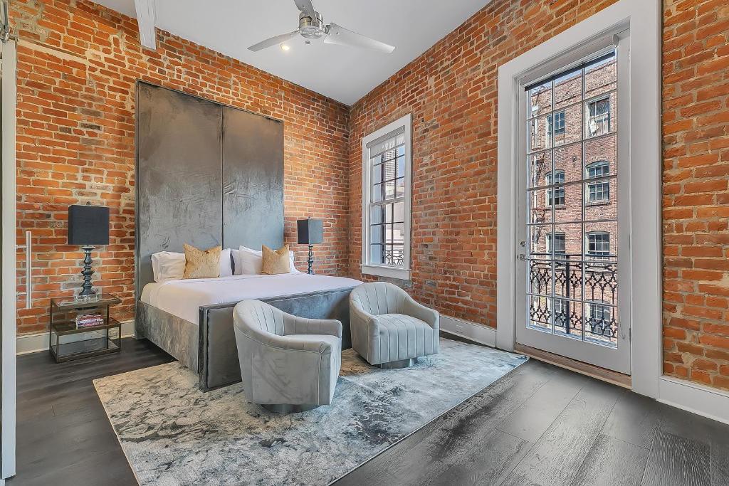 a bedroom with a bed and a brick wall at The Magnolia in New Orleans