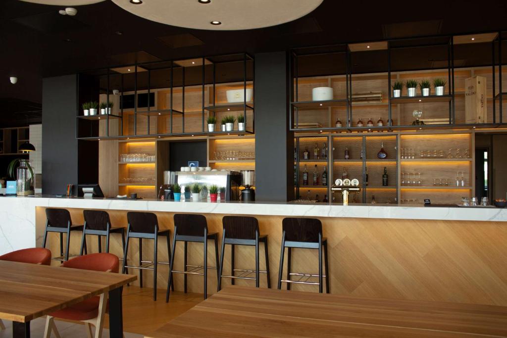 a bar in a restaurant with wooden tables and chairs at Park Inn by Radisson Vilnius Airport Hotel & Conference Centre in Vilnius