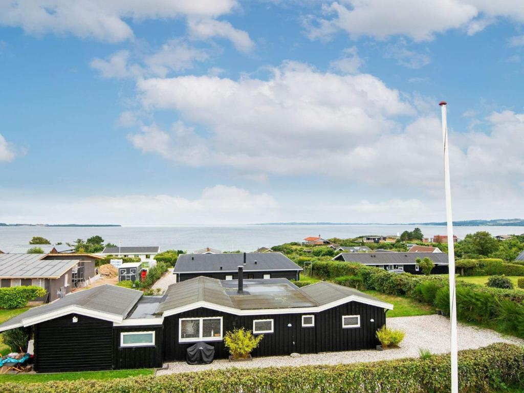 エーベルトフトにある6 person holiday home in Ebeltoftの旗の前の黒い家