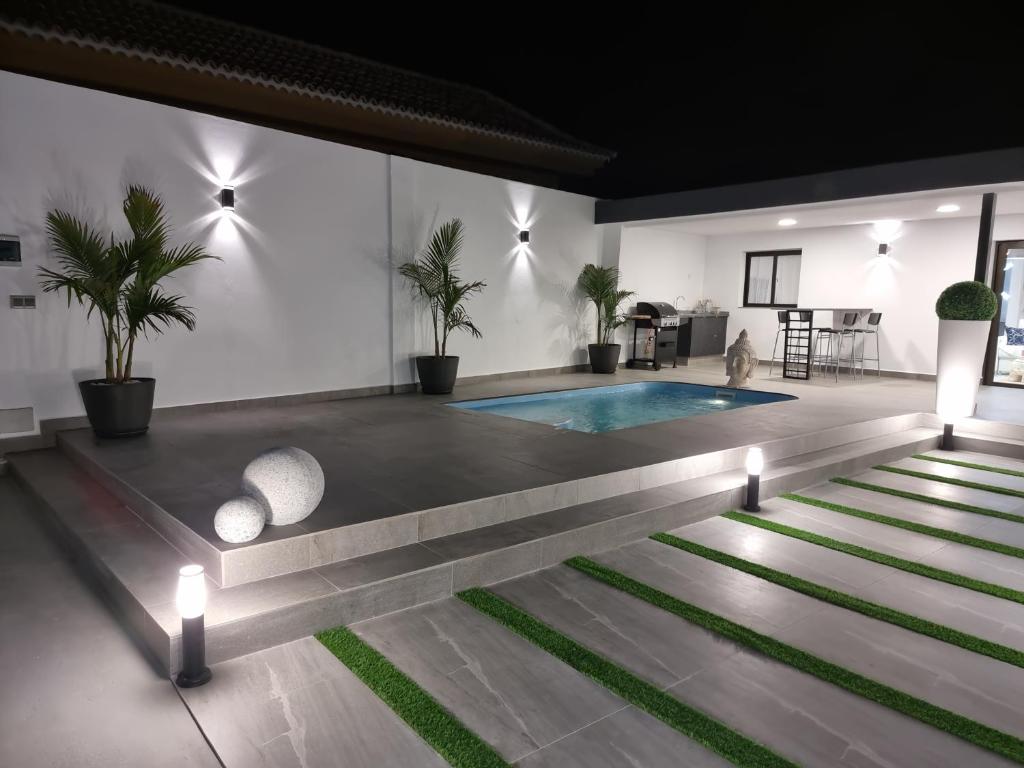 a swimming pool in a room with plants and lights at ViLLA DREAMS JF in Arona